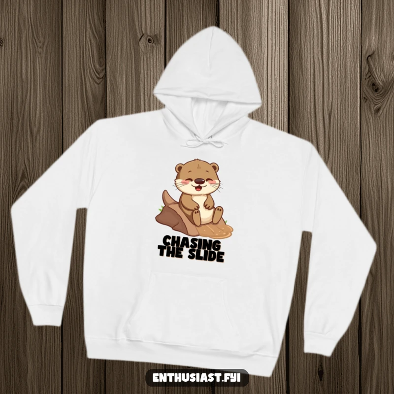 Funny hoodie featuring a playful otter joyfully sliding down a small, muddy incline, perfect for cozy, humorous relaxation.