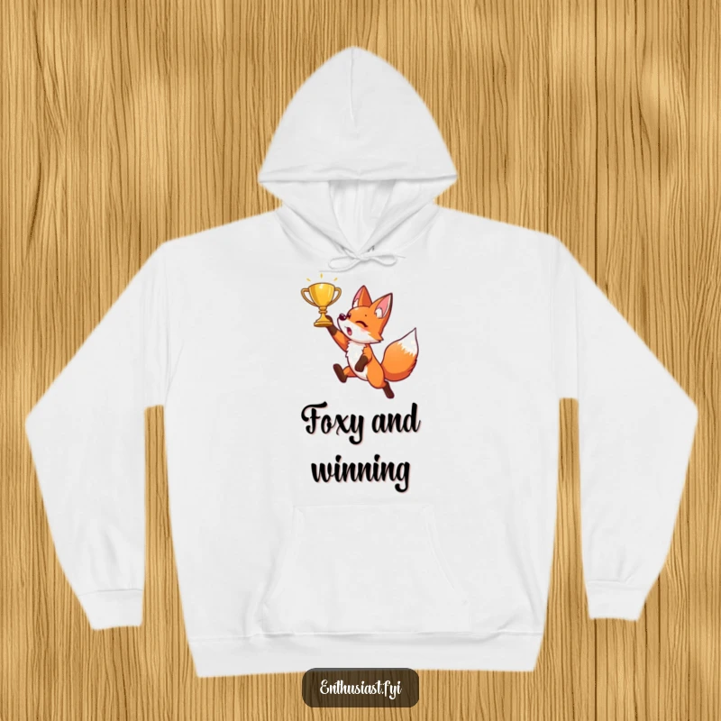 Funny hoodie showing an energetic fox character mid-air, leaping joyfully towards a sparkling golden trophy. Motivational and cozy.