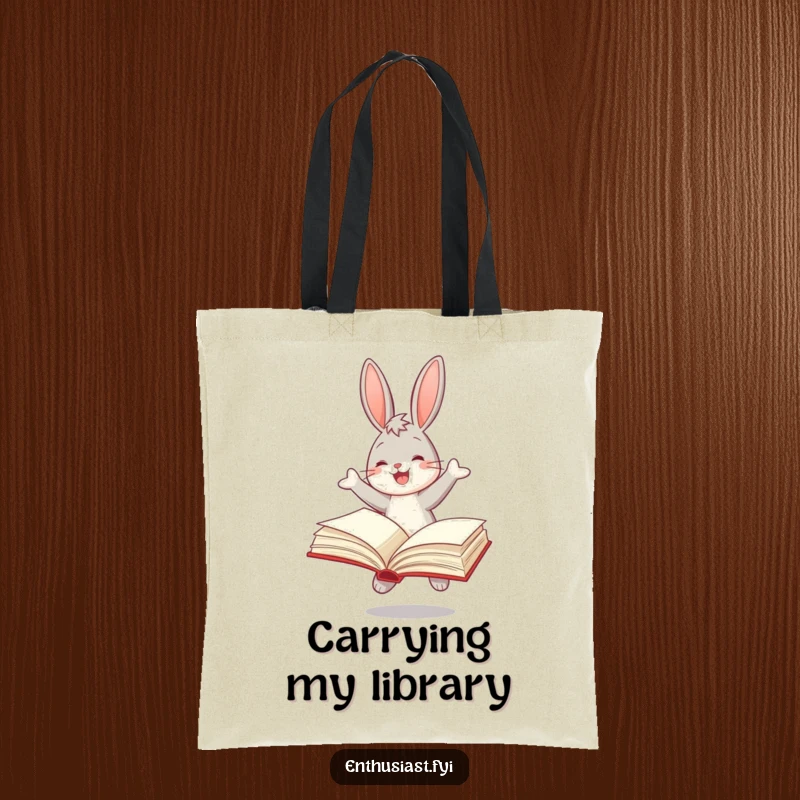 Funny tote bag with a joyful bunny bouncing and reading a large book, ideal for carrying literary treasures.